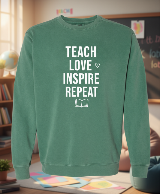 Green sweatshirt with 'TEACH LOVE INSPIRE REPEAT' text on a white background