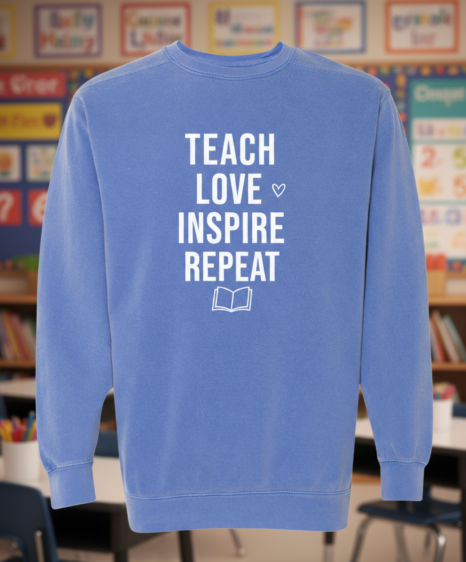 Blue sweatshirt with 'Teach Love Inspire Repeat' text on a white background