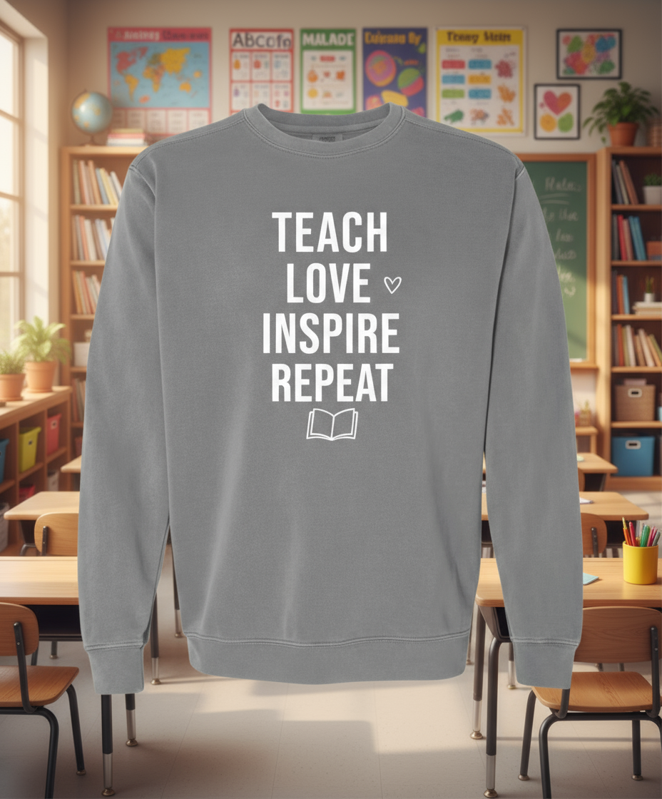 Gray sweatshirt with 'TEACH LOVE INSPIRE REPEAT' text on a white background